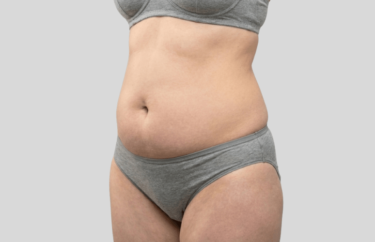 Kvinde med eksponeret mave med gråt undertøj